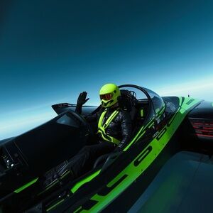 HANDCRAFTED digital art print jet flying Black Racing Suit with Neon Green jet